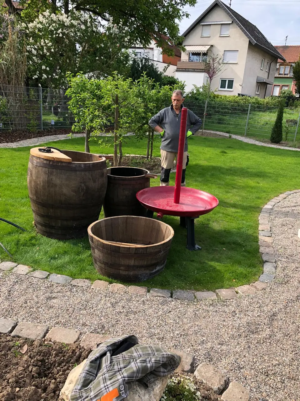 Weinfass-Pflanzgefäße an einer Wasserstelle